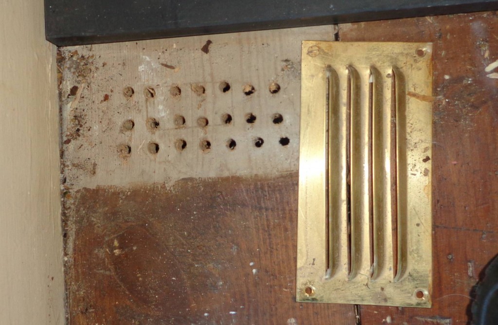 A vent removed to reveal small drilled holes behind